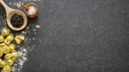 Homemade Italian traditional tortellini pasta. Dark stone background with copy space.の写真素材