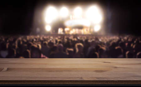 Empty table top for product display montage. Crowd at concert, summer music festival blurred in the background.の写真素材