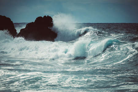Waves crash along the black lava rock cliffs. Lanzarote, Canary Islands.の写真素材