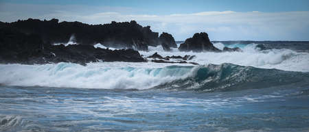 Waves crash along the black lava rock cliffs. Lanzarote, Canary Islands.の写真素材