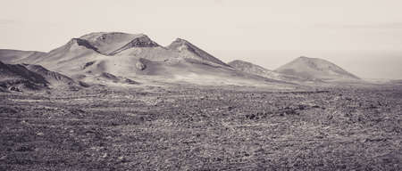 Beautiful volcanic landscape background. Mountain range with lava fields in the foreground. Lanzarote, Canary Islands.の写真素材