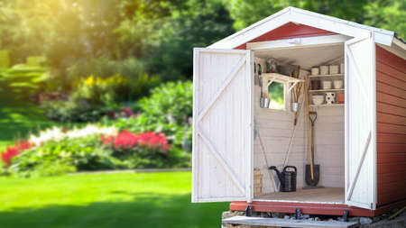 Storage shed filled with gardening tools. Beautiful green botanical garden in the background. Copy space for text and product display.の写真素材