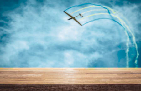 Glider aircraft pull off a aerobatic loop, color trails in air show. Empty table top for product display montage background.の写真素材
