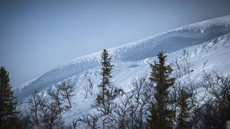 Avalanche risk zone. Landscape with dramatic cliff side on snowy mountain.の写真素材