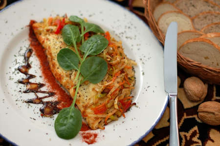 omelette garnished by vegetables and greensの写真素材