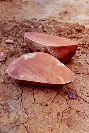 Two halves of a broken granite stone lying in the sand on the beach.の写真素材