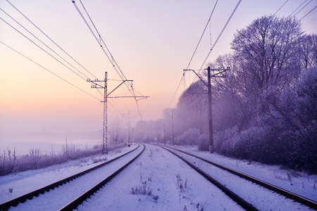 Winter railway landscape in the provincial countryside of Finland on a snowy, foggy morningの写真素材