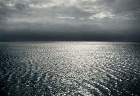 The ocean at night, showing vastness, sparkling details on the waves, the calm before the storm...a...