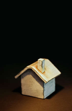 Toy house on Dark earth tone background 