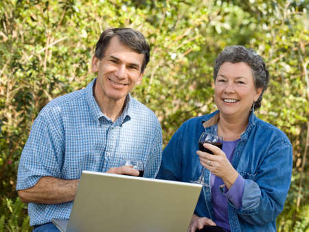 Happy mature couple enjoying wine and planning their retirement options.