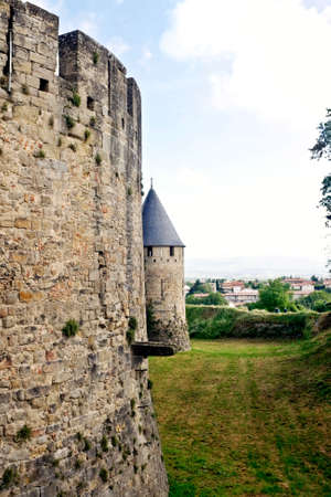 Early morning view of the wall and a tower at Carcassonne Castle in France.の写真素材