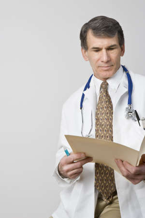 Doctor reading patient's chart. 3/4 View with room for textの写真素材