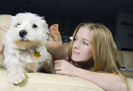 Cute young woman with her good friend, a White West Highland Terrier. Focus on the girl.