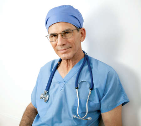 Portrait of senior male doctor or nurse with stethoscope, scrubs, cap. Friendly and responsible looking.の写真素材