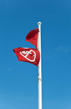 Two red flags on a flagpole at a Gulf Coast Beach mean no swimming or fishing due to dangerous surf, storms, or in this case, toxicity from an oil spill の写真素材