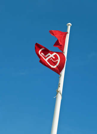 Two red flags on a flagpole at a Gulf Coast Beach mean no swimming or fishing due to dangerous surf, storms, or in this case, toxicity from an oil spill  You may be arrested for swimming or fishing in violation of the warning  Symbol for の写真素材