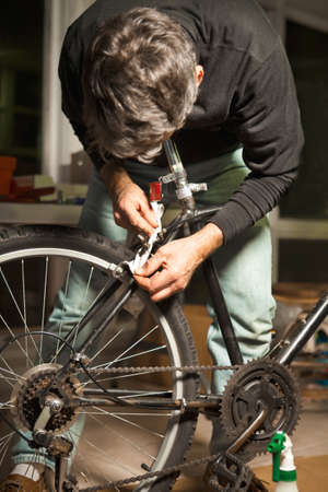 Man Repairing and Rebuilding An Old Bicycleの写真素材