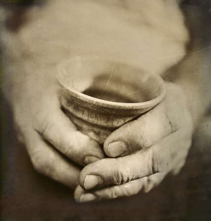 Vintage Style Photo of Man s Worn Hands Holding Pottery Cupの写真素材