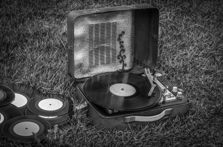vintage portable turntable and vinyl records on the grassの写真素材