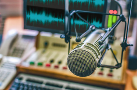 professional microphone, sound mixer and sound wave form on computer screenの写真素材