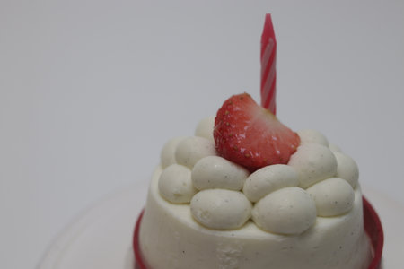 Birthday cake with strawberry on top isolated on a white background.の写真素材