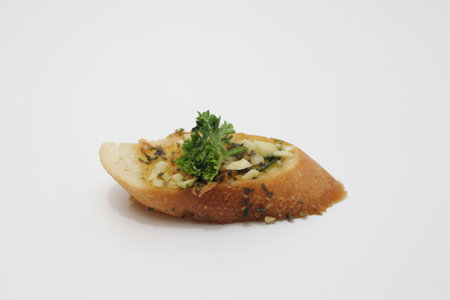 Toasted baguette with parsley on a white background.の写真素材