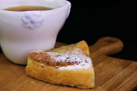 Close up Pear Tart topped with Crushed Pistachio nuts on Black Background