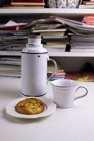 Cinnamon Bun and Hot Coffee on the working table in the morning