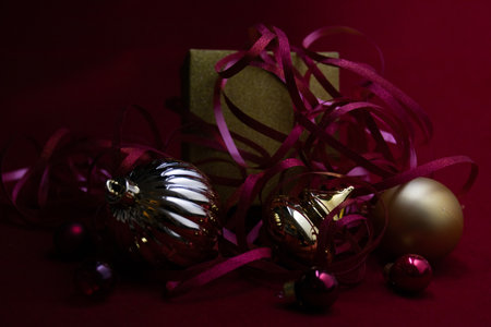 Christmas Ornaments for Decoration. Red berries, Pine Cone, Hanging Balls, Green Fir and Red Ribbon. Red Backgroundの写真素材