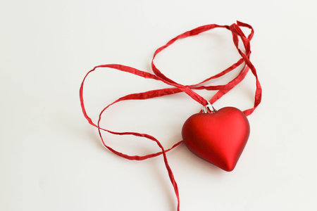 red heart with red ribbon on white backgroundの写真素材