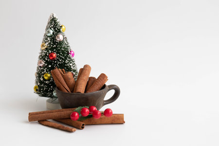 Little Christmas Tree, Cinnamon Stick in a cup , red berries, white background