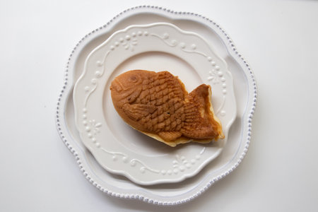 A piece of Japanese Dessert, Taiyaki on  white plate isolated on white background, top view.の写真素材