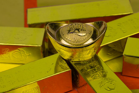 Gold ingots and chocolates on a red background closeup