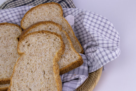 Sliced bread in a wicker basket on a white background.