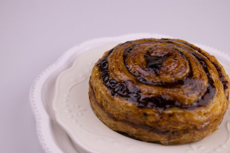 Close up a Cinnamon Bun with Raisin on a white plate on a white background