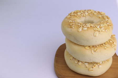 Bagels with sesame seeds on a wooden board on a white background
