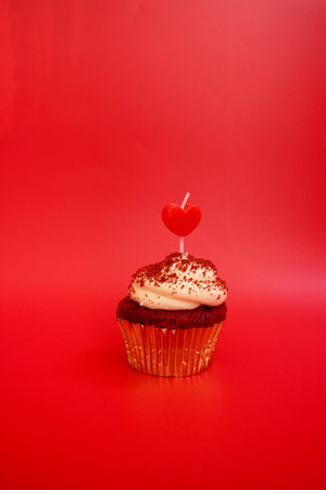 A Cup Cake topped with Red Heart on Red Backgroundの写真素材