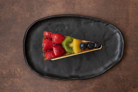 Delicious Danish fruit Cake on white background , topped with fresh Strawberries, Kiwi , Peach and blueberryの写真素材