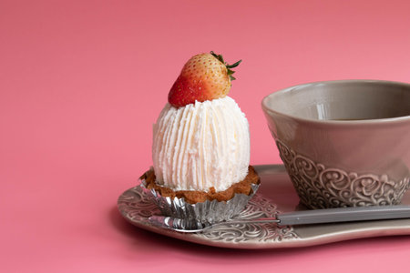 Cup of coffee and strawberry cake on pink background with copy space