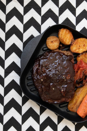 Delicious Dish Pork chop with gravy with grilled vegetable , tomatoes, carrot and Potatoes , on white backgroundの写真素材