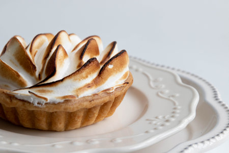 Lemon Tart with whipped cream on a white plate on a white backgroundの写真素材