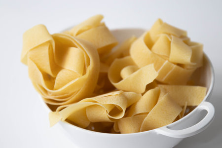 Close up of uncooked italian pasta in a white bowl.の写真素材