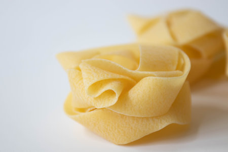 Close up of uncooked tagliatelle pasta on white backgroundの写真素材