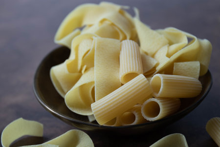 close up of a bowl of uncooked italian pasta , Pappardelle , on rustic  backgroundの写真素材
