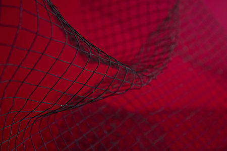Close up Black Rustic Wire Mesh on red Backgroundの写真素材