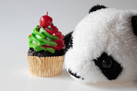 Cupcake topped with red cherry with a panda bearの写真素材