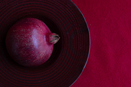 Ripe pomegranate on a Red plate on a red background, Chinse New Yearの写真素材