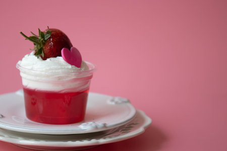 Strawberry jelly topped with white whip cream and Fresh Strawberry with Pink Heart, Pink Backgroundの写真素材