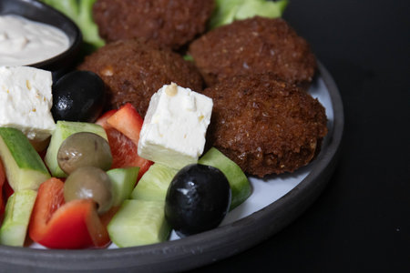 Falafel with fresh vegetables on a black background. Healthy food.の写真素材