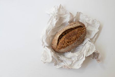 Whole wheat bread on crumpled paper isolated on white background